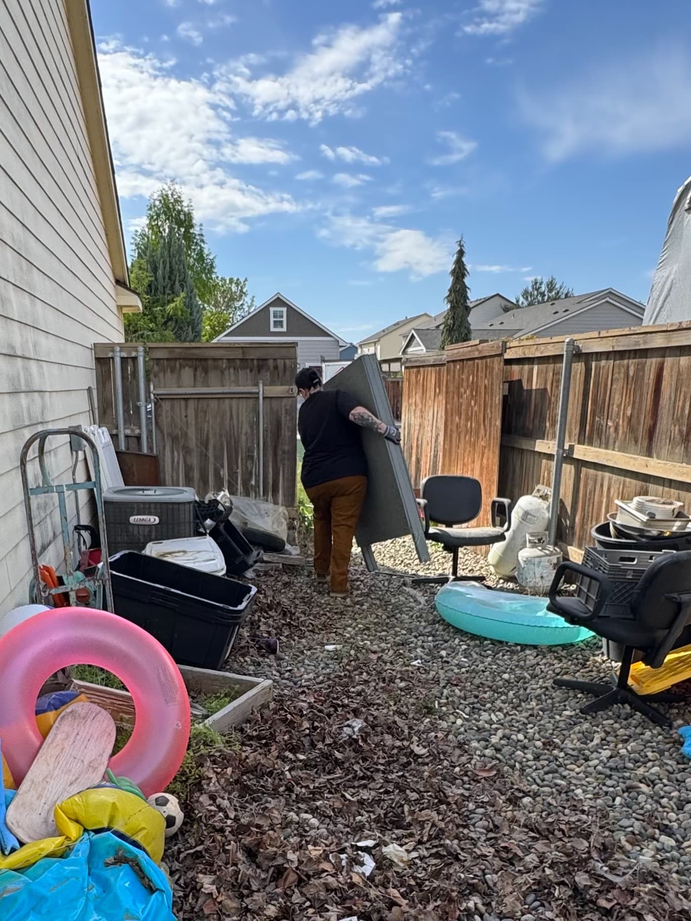 Higher Hauling crew member removing a bulky outdoor item from a side yard